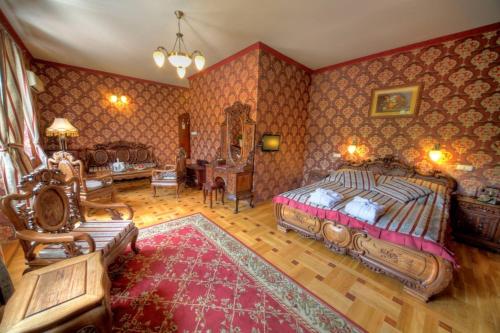 ein Schlafzimmer mit einem Bett und ein Wohnzimmer in der Unterkunft Fried Kastély Hotel Simontornya in Simontornya