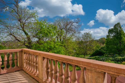 a wooden balcony with trees in the background at Fried Kastély Hotel Simontornya in Simontornya