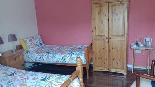 a bedroom with a bed and a dresser next to a cabinet at Bundoran Guesthouse in Bundoran