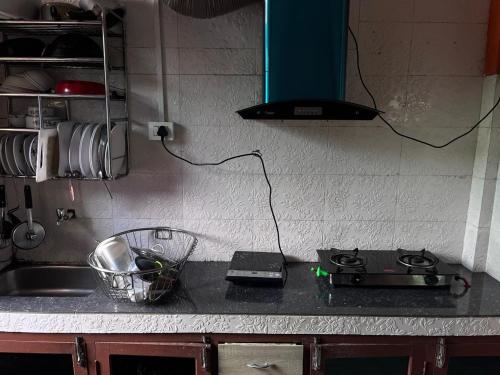 a kitchen counter with a stove and a sink at Happy Homestay Sittong in Mangpu