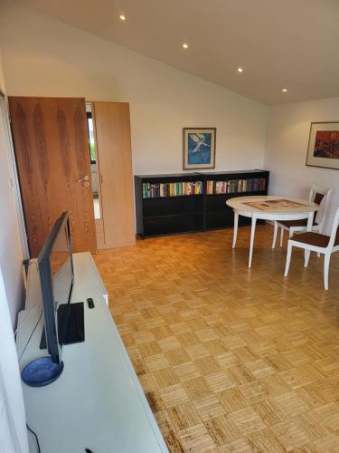sala de estar con escritorio, TV y mesa en Taunus Wohnen und Arbeiten in Friedrichsdorf, en Friedrichsdorf