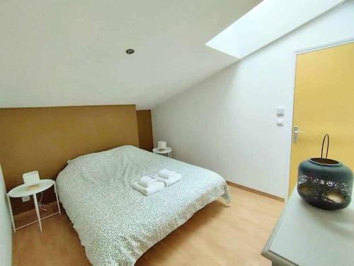 a bedroom with a bed with towels on it at Maison charmante avec jardin in Coutras
