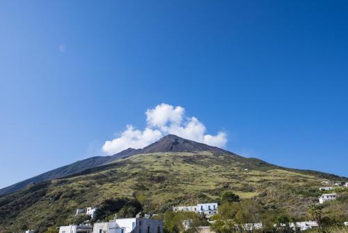 a mountain with clouds on top of it at Villa Mareblu Luxury Holiday Apartment direttamente sul mare in Stromboli