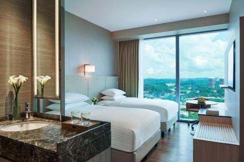 two beds in a hotel room with a large window at Courtyard by Marriott Singapore Novena in Singapore