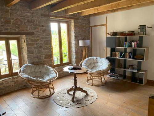 a living room with two chairs and a table at Entre Tarn et Causses in Le Recoux
