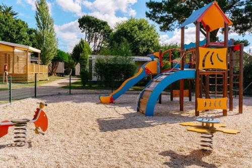 - une aire de jeux avec toboggan dans le sable dans l'établissement Mobil home CARNAC, à Carnac