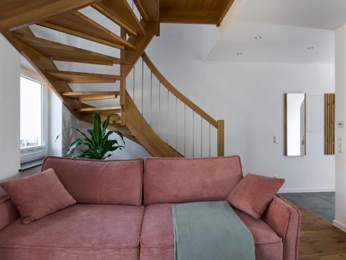 a living room with a couch and a staircase at HAUSmeier in Bad Reichenhall