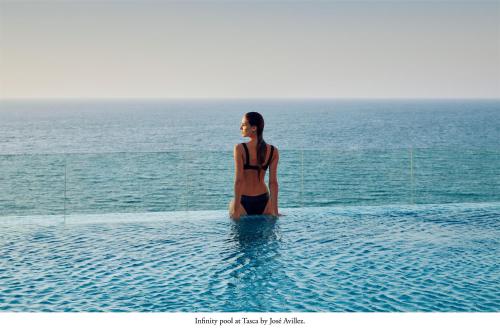 una mujer parada en el agua en una piscina en Mandarin Oriental Jumeira, Dubai en Dubái