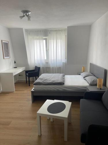 Wegener Apartments في مانهايم: غرفة نوم بسرير واريكة وطاولة