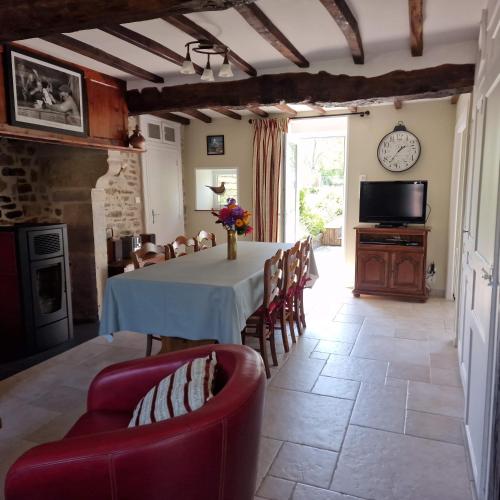 une cuisine et une salle à manger avec une table et des chaises dans l'établissement Le Dy en fleurs, à Saint-Maurice-en-Cotentin