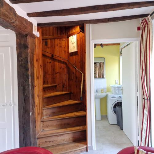 un escalier menant à une salle de bains dans une maison dans l'établissement Le Dy en fleurs, à Saint-Maurice-en-Cotentin