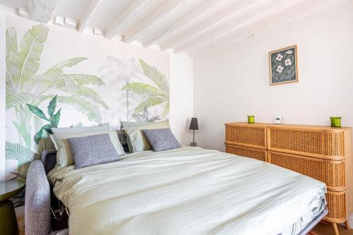 une chambre avec un lit avec un papier peint tropical dans l'établissement GuestReady - Modern comfort near Palais Garnier, à Paris
