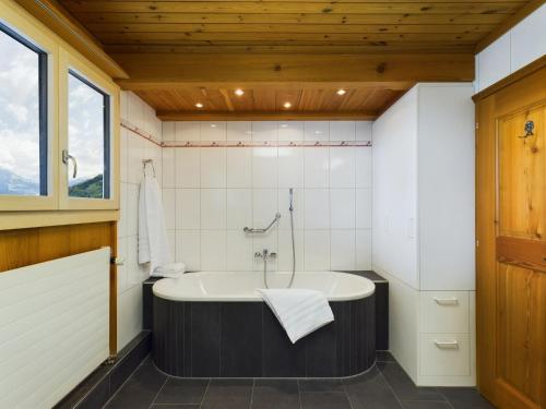 baño con bañera y ventana en Bergblick Lodge - 3 Sterne Garni - Neueröffnung, en Aeschi