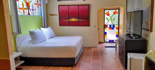 a bedroom with a bed and stained glass windows at Suites Arcoiris in Villa de Leyva