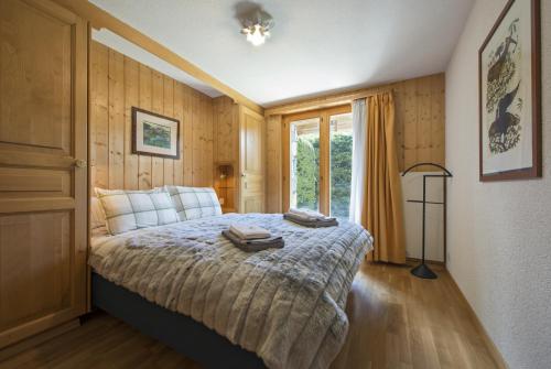 a bedroom with a bed and a large window at Apartment Vicomte in Verbier