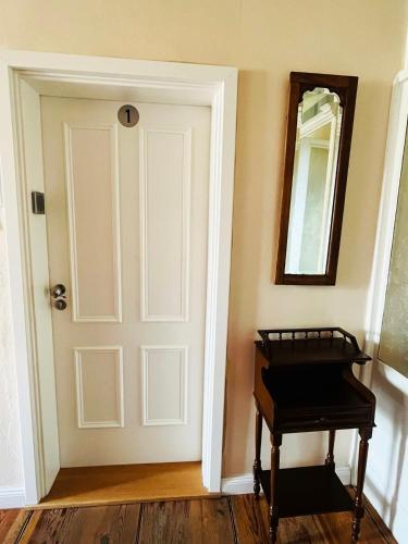 a room with a door and a mirror and a piano at Altes Pfarrhaus Neustädt in Neustädt
