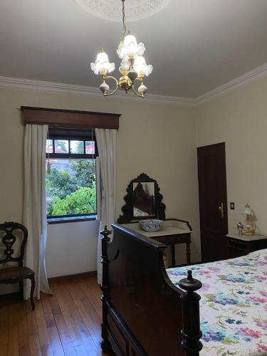 ein Schlafzimmer mit einem Bett, einem Spiegel und einem Fenster in der Unterkunft Casa da Quinta da Mata in Cabeceiras de Basto