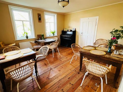 - une salle à manger avec du parquet, des tables et des chaises dans l'établissement Altes Pfarrhaus Neustädt, à Neustädt