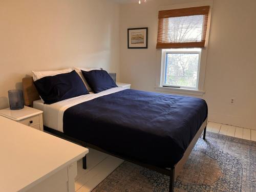 una camera da letto con un letto con cuscini blu e una finestra di OH Victoria Hotel - Sand Dune Suite 4B 3BTH a Hampton 