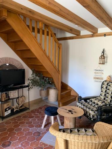 un salon avec un escalier et un canapé dans l'établissement Appartement Duplex 2 pièces - Corps de ferme, à Montépilloy