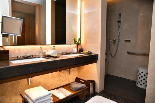 uma casa de banho com 2 lavatórios e um chuveiro em Fairmont Quasar Istanbul Hotel em Istambul