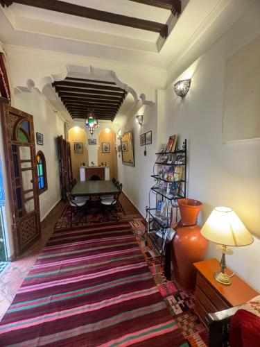 a living room with a table and a large rug at Riad Assalam in Marrakech