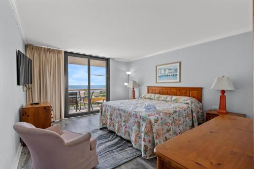 默特爾海灘的住宿－Ocean Creek Resort B4 - Oceanfront - Windy Hill，一间卧室配有一张床、一张桌子和一个窗户。