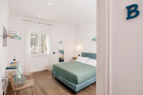 1 dormitorio con 1 cama, 1 silla y 1 ventana en 0.8 Guest House, en Porto Ercole