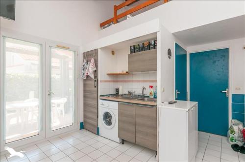 une cuisine avec un évier et une machine à laver dans l'établissement Villa dans résidence jardin piscine parking près de la mer, à Vic-la-Gardiole