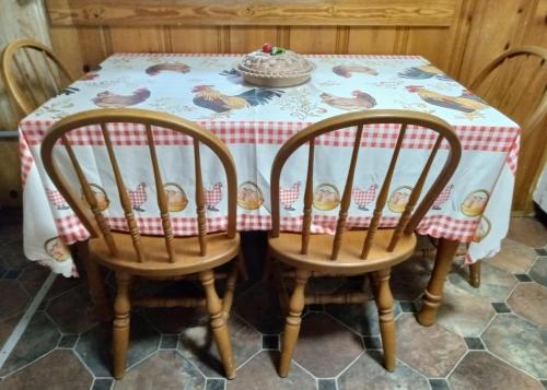 a table with two chairs and a tablecloth with birds on it at The Evening Shade River Lodge and Cabins in Chimney Rock