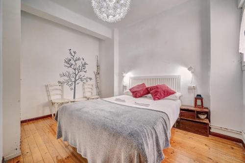 Un dormitorio blanco con una cama grande con almohadas rojas en Jarauta 18 by Clabao, en Pamplona