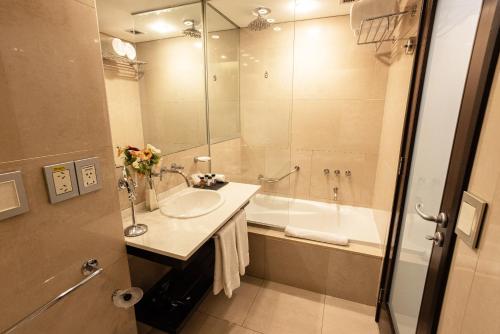 uma casa de banho com um lavatório, um chuveiro e uma banheira em Libertador Hotel em Buenos Aires