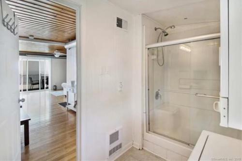 a bathroom with a shower and a glass door at Cozy Beach - Direct Waterfront! in East Haven