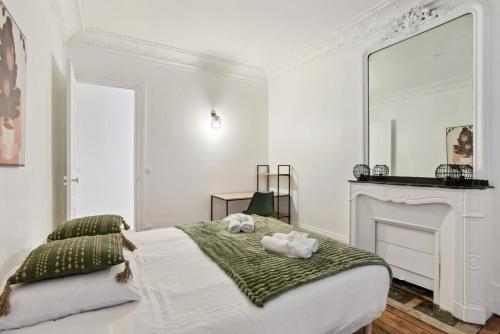 une chambre avec un lit avec deux animaux en peluche dessus dans l'établissement 523 Suite Batignolles - Superbe Appartement, à Paris