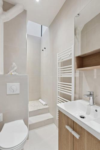 une salle de bain blanche avec des toilettes et un lavabo dans l'établissement 523 Suite Batignolles - Superbe Appartement, à Paris