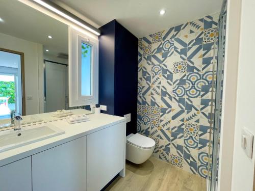 une salle de bain avec un lavabo, des toilettes et un miroir dans l'établissement PGH N12 - Thalasso & Plage à 2 pas, Parking Privé, à La Grande Motte