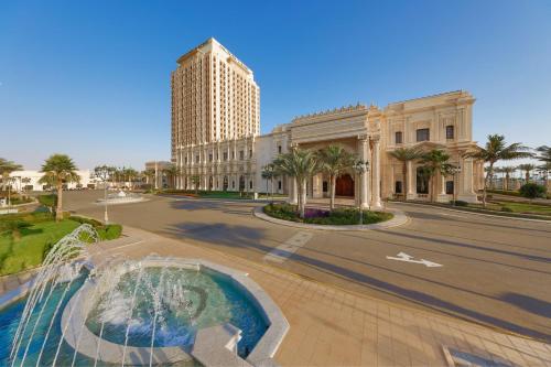 ein Gebäude mit einem Brunnen in der Mitte einer Straße in der Unterkunft The Ritz-Carlton Jeddah in Dschidda