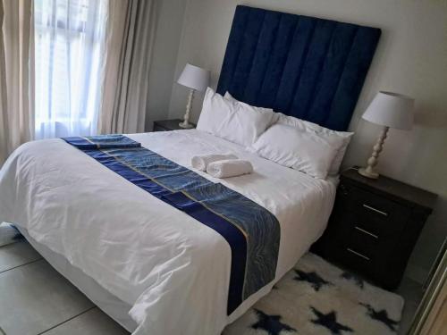 a bedroom with a large bed with a blue headboard at The Blyde Crystal Lagoon in Pretoria