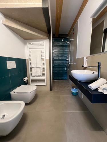 a bathroom with two sinks and a toilet and a shower at Caivano Rooms New Opening in Torri del Benaco