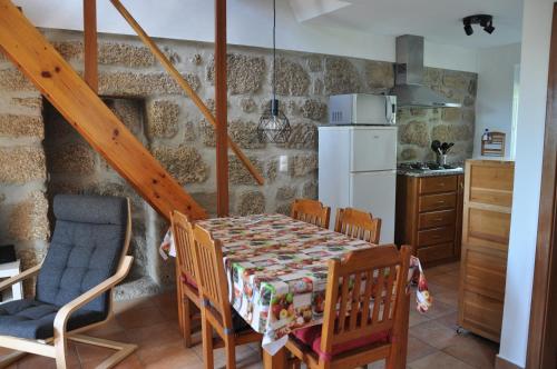 a kitchen and dining room with a table and chairs at Quinta da Encavalada in Nogueira do Cravo
