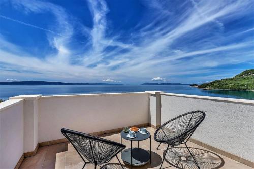 a balcony with two chairs and a table and the ocean at Villa Legero mit Pool 300 Meter zum Strand in Drašnice