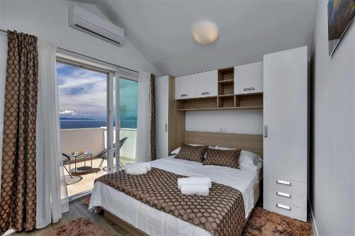 a bedroom with a bed with a view of the ocean at Villa Legero mit Pool 300 Meter zum Strand in Drašnice