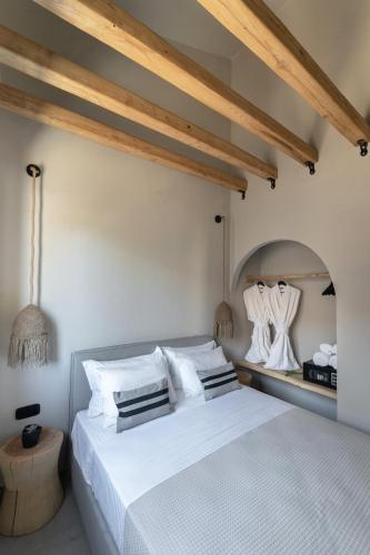 a bedroom with a white bed and a mirror at Amo Golden Suites in Chrysi Ammoudia