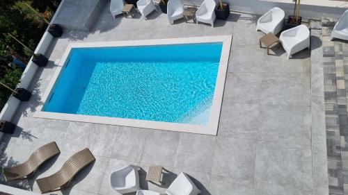 an overhead view of a swimming pool with white chairs and a swimming pool at Villa SHARK 2 with a pool in Novalja