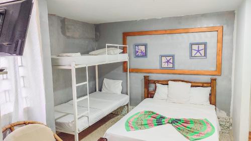 a small room with two bunk beds with a bow tie at Hotel Casa Telma in Santa Marta