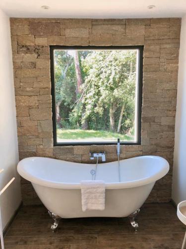 une baignoire dans une salle de bain avec une fenêtre dans l'établissement Villa Porto Vecchio centre, à Porto-Vecchio