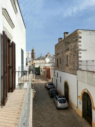 a street with cars parked in a alley between buildings at DD's -Guest House- in Taviano