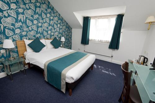 um quarto de hotel com uma cama e uma janela em Basingstoke Country Hotel & Spa em Hook
