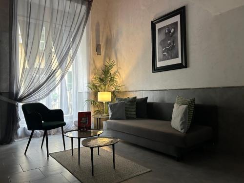 een woonkamer met een bank en een stoel bij A un passo dal Castello Maschio ANGIOINO Appartment in Napels