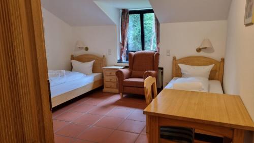 Habitación pequeña con 2 camas y silla en Hotel Lohauser Hof en Düsseldorf